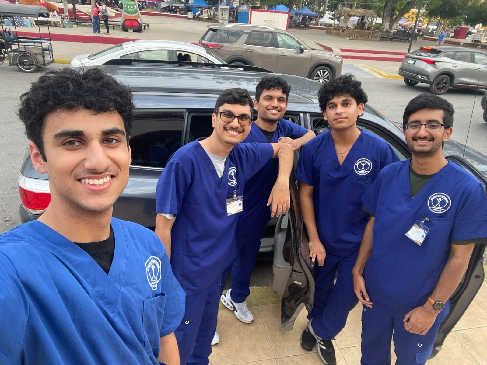 Michigan chapter volunteers in blue scrubs smile together on arrival for the December 2025 Mexico mission