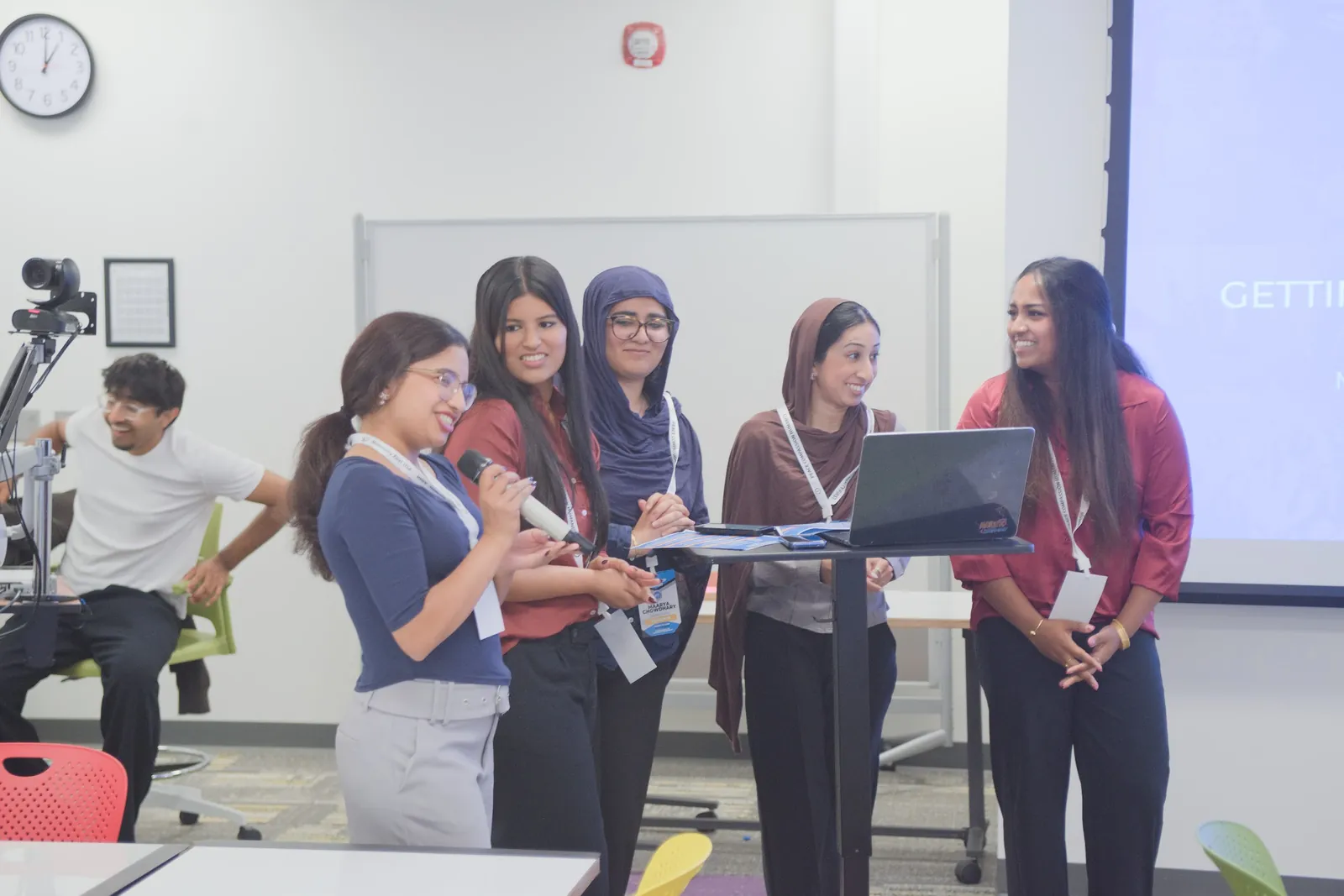 A team of students presents at a podium while one speaks into a microphone at Summit 2026