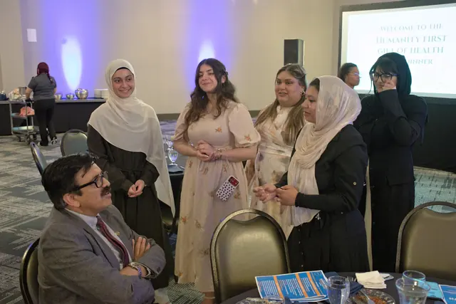 Guests stand and chat around a banquet table as the evening gets underway at the Gift of Health Gala 2026.