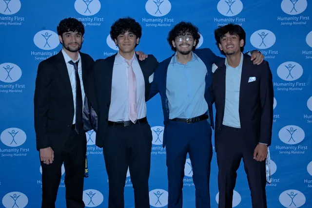 Four young men in suits pose arm in arm in front of a Humanity First backdrop at the Gift of Health Gala 2026.