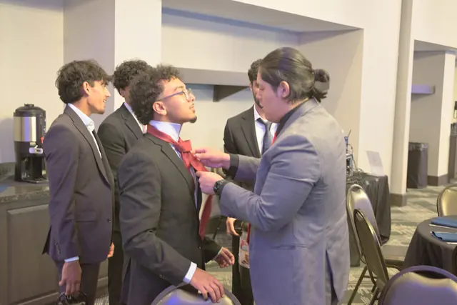 A student helps a fellow delegate straighten his bow tie before the Gift of Health Gala