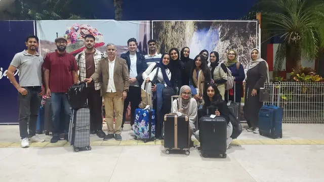Loyola University Chicago students and mission leaders stand with their luggage in an airport terminal on arrival for Gift of Health Mexico.