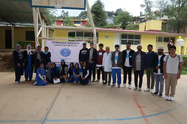 Loyola University Chicago students, physicians, and mission leaders pose on the clinic court in front of a Jornada Medica banner in Mexico.