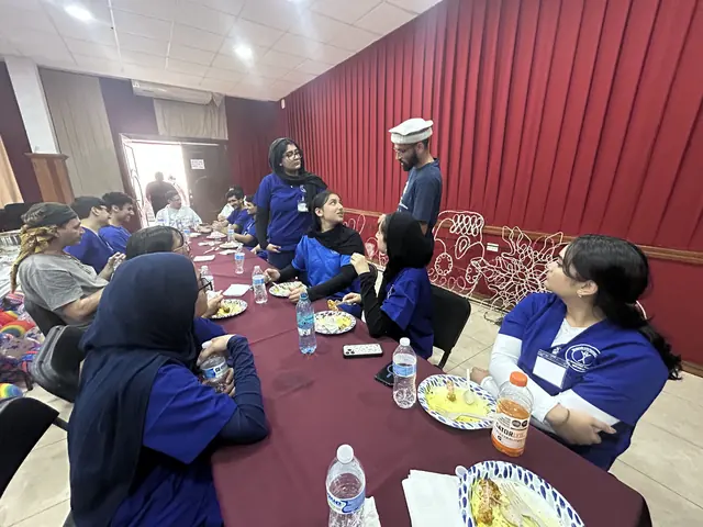 Volunteers in scrubs share a meal together at a long table after clinic hours at the Gift of Health mission in Mexico.
