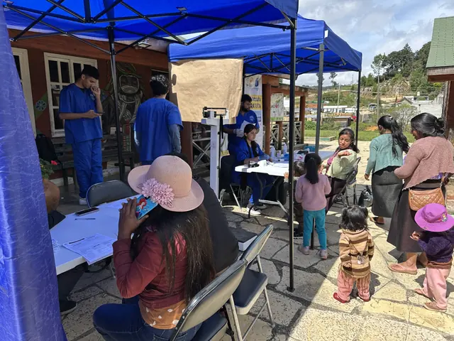 A patient is weighed on a scale beside the clinic tent