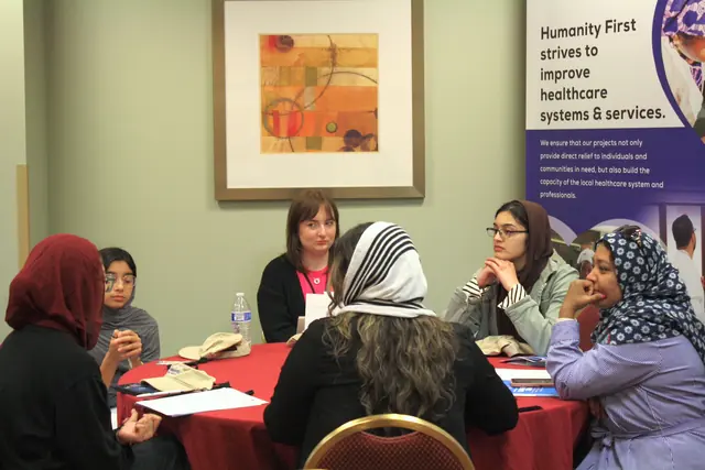 Delegates gather around a table in focused discussion during a small group session at the HFSD Leadership Summit '23.