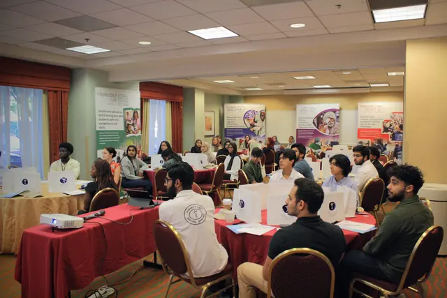 A full room of student delegates seated at round tables listens during a session at the HFSD Leadership Summit '23.