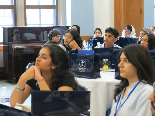 Delegates listen attentively at their tables