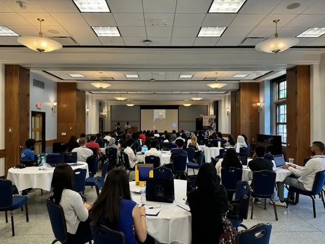 A packed hall of delegates at round tables faces the stage during the 2024 HFSD Leadership Summit.