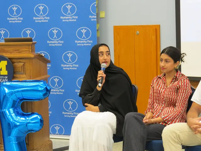 A student panelist speaks into a microphone beside a fellow panelist at the 2024 HFSD Leadership Summit.