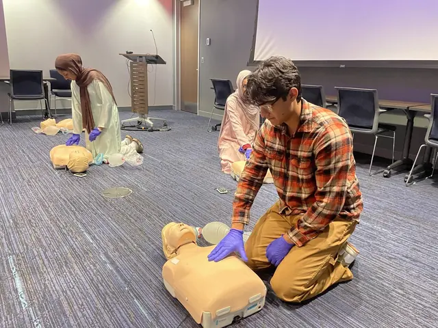 A delegate performs chest compressions on a CPR manikin