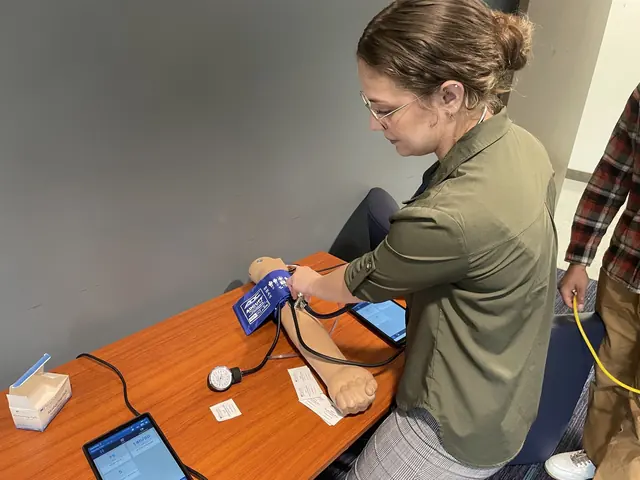 A delegate practices with an automated external defibrillator trainer