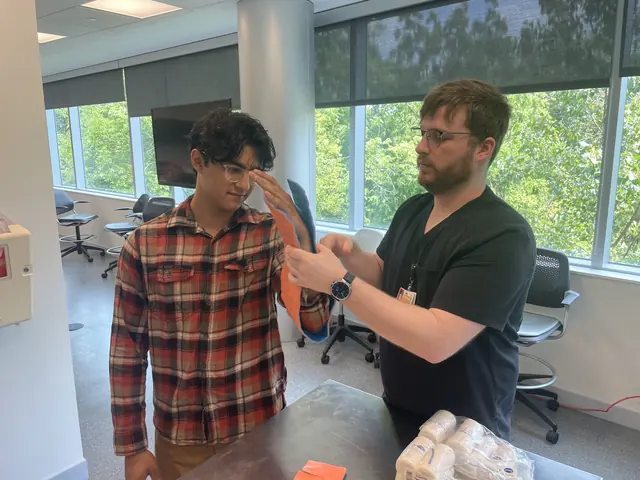 An instructor helps a student fit a splint to his arm during emergency training at the 2025 Leadership Summit.