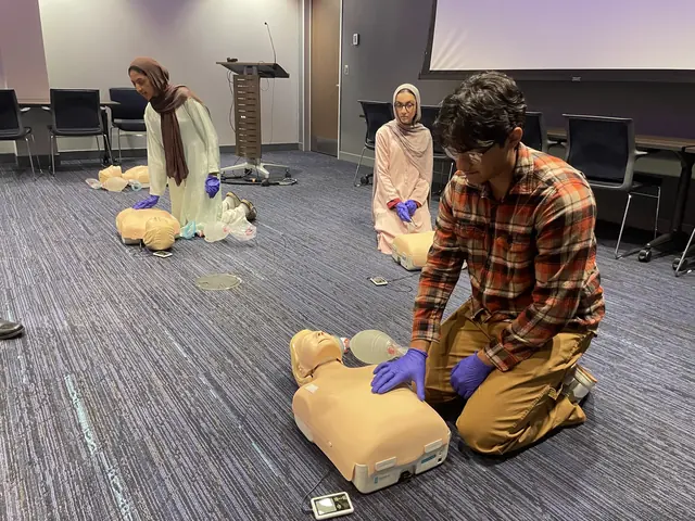 A student in gloves practices chest compressions on a CPR manikin during emergency training at the 2025 Leadership Summit.