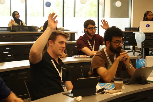 Delegates raise their hands during a leadership session