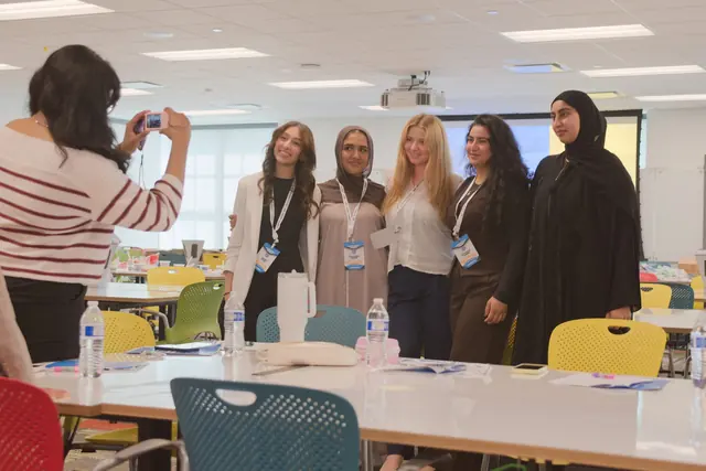 Delegates pose for a group photo between sessions in a Summit 2026 workshop room