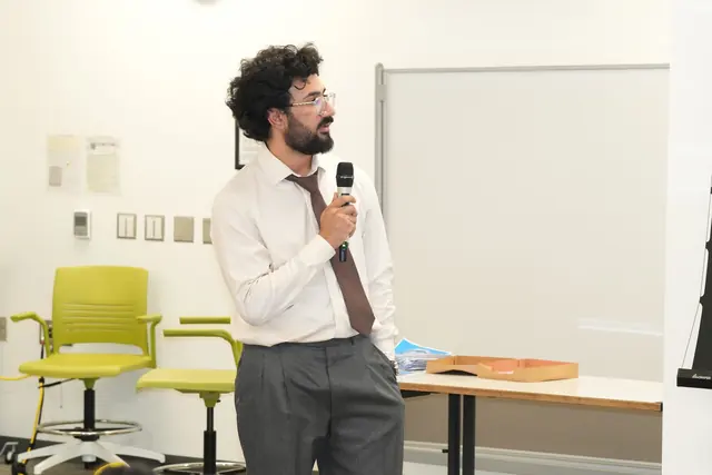 A speaker in a shirt and tie addresses participants with a microphone during a session at the HFSD Leadership Summit 2026.