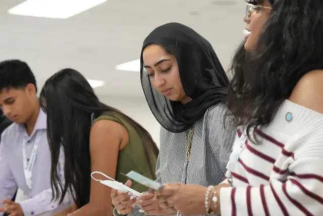 Students focus closely as they read labels and pack supplies into kit boxes at the HFSD Leadership Summit 2026.