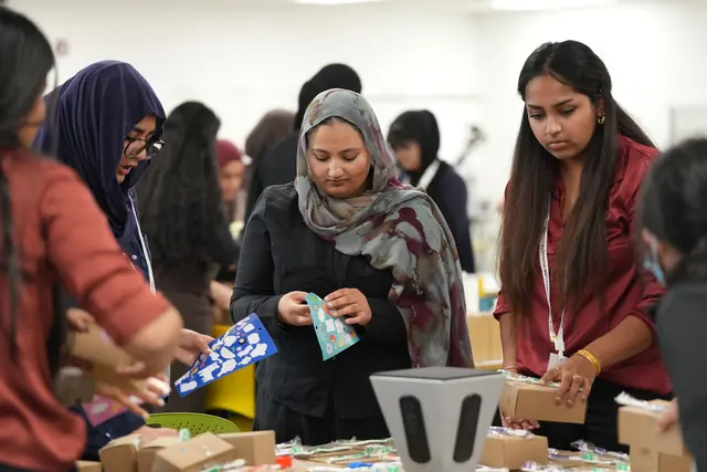 Students sort colorful supply packets and fill kit boxes at a busy table at the HFSD Leadership Summit 2026.